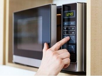 male-hand-while-using-to-set-a-time-in-micro-wave-oven